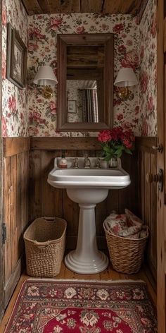 a white sink sitting under a bathroom mirror next to a wooden wall with flowers on it