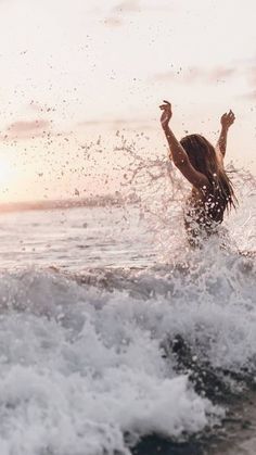 a person riding a wave on top of a surfboard in the ocean at sunset