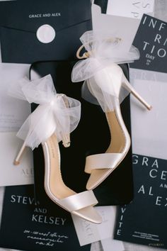 a pair of white high heel shoes sitting on top of a black and white box