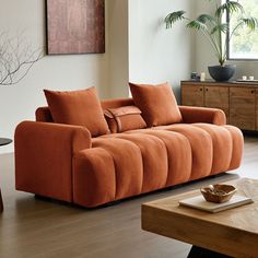 a living room with an orange couch and coffee table