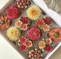 cupcakes decorated with flowers in a box