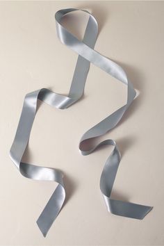 a silver ribbon is on the wall with it's end curled up into a spiral