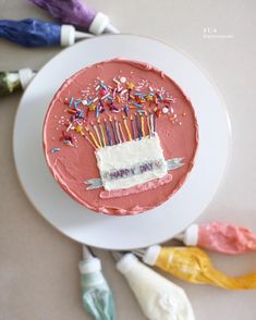 a birthday cake on a plate with sprinkles and icing around it