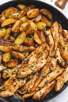 chicken and potatoes in a skillet with parsley on the side for garnish