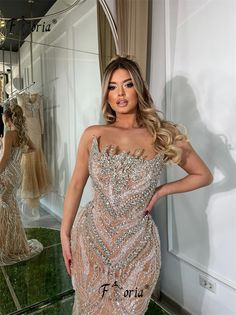 a woman standing in front of a mirror wearing a dress with sequins on it