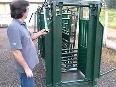 a man standing next to a green metal structure