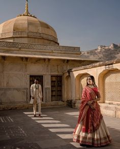 a man and woman standing in front of a building