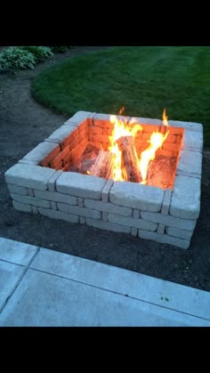 a fire pit sitting on top of a cement slab in the middle of a yard