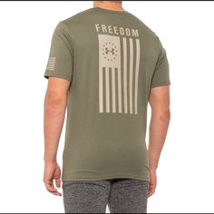 a man wearing a green t - shirt with the american flag on it, back view