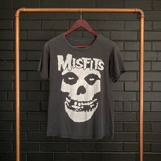 VINTAGE :: 90s MISFITS Skull Tee  COLOUR :: Black  FIT/TAG :: S MATERIAL :: Cotton  CONDITION :: Excellent   MEASUREMENTS ::  Armpit to Armpit Width - 46cm // 18"   Total Length CB Neck to Bottom - 58.5cm // 23"   Arm Length from Shoulder Seam to Sleeve Edge - 16.5cm // 6.5"    DETAILS :: Perfectly worn in preloved Misfits Skull Tee. Front Print Only. Soft feel, excellent condition. Cracked print. Small amber marks on front seen in images. NOTE :: Each hand selected vintage or preloved piece is Distressed Skull T-shirt In Edgy Style, Vintage Skull Print Tops For Streetwear, Grunge Band Logo Tops For Halloween, Vintage Distressed Halloween T-shirt, Grunge Tops With Band Logo For Halloween, Vintage Cotton Tops With Skull Print, Vintage Distressed Tops For Halloween, Distressed Skull Top In Punk Style, Acid Wash Skull Print Top For Streetwear