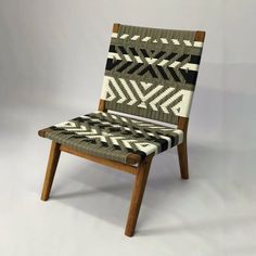 a wooden chair with an upholstered seat and armrest made out of woven fabric