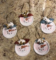 four snowman ornaments are hanging on the counter