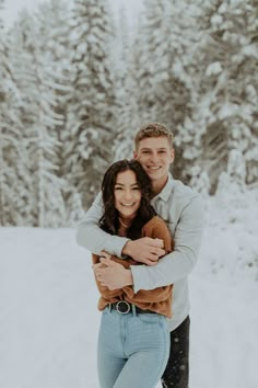 a man and woman are hugging in the snow