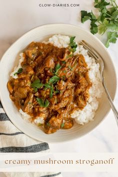 a white bowl filled with rice and meat on top of a table next to a fork