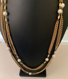 This pretty shiny three layer gold chain necklace is super long and can be worn doubled  for a short necklace.  It has white lucite faux pearl pearl accent beads.  The necklace is 57 inches long.  This is in great like new condition. I specialize in finding fun wearable jewelry please browse my shop for more options. I box all jewelry sales ready to be given as gifts. Multi-strand Layered Pearl Chain Necklace For Parties, Multi-strand Layered Pearl Necklace For Party, Gold Multi-strand Pearl Necklace With Adjustable Chain, Gold Multi-strand Pearl Necklace, Gold Layered Necklace With Pearl Chain For Party, Gold Multi-strand Pearl Layered Necklace, Gold Multi-strand Pearl Chain Necklace, Gold Pearl Multi-strand Layered Necklace, Gold Multi-strand Pearl Necklace For Party