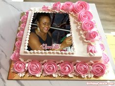 a cake with pink roses on it and a woman's face in the center