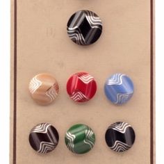 six different colored buttons in a wooden frame