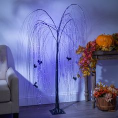 a white chair sitting next to a tall tree with butterflies on it's branches