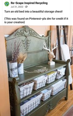 a green bench with baskets on it in front of a wall and an antler's head