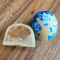 two pieces of soap sitting on top of a wooden table next to an egg shaped like a plane