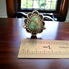 Turquoise ring - large turquoise nugget - signed Annie Chapo - size 7. Elevate your style with this stunning turquoise ring! Crafted with a large, natural turquoise nugget and signed by A Chapo, this size 7 ring is sure to make a statement. Embrace the unique beauty of natural stone and elevate any outfit with this one-of-a-kind piece. Clearance item sales are final. Western Style Ring With Large Stone For Gift, Western Style Untreated Turquoise Ring Gift, Untreated Western Turquoise Ring As Gift, Untreated Western Style Turquoise Ring Gift, Artisan Turquoise Ring With Large Stone, Artisan Turquoise Ring With Large Stone Collectible, Unique Turquoise Ring With Patina, Unique Untreated Turquoise Emerald Ring, Collectible Green Turquoise Ring