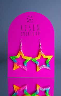 A pair of handmade glittery resin earrings, designed to make you look & feel extra. Playful, eye-catching and vibrant, perfect for festivals, parties, special occasions or just to add a touch of sparkle to your everyday look.  Each pair is meticulously crafted with love and attention to detail, ensuring that you receive a unique piece of jewellery that will make you shine.  A combination of high-quality resin and carefully selected glitters creates a mesmerising effect that catches the light and captures attention. ~ RAINBOW STAR ~ Dimensions - w3.8 x h3.8cm.  Silver plated fish-hook style earrings. Designed and hand crafted from my home studio in Bedfordshire, UK. All jewellery is made to order. Thanks for looking! x Multicolor Glitter Dangle Earrings, Multicolor Glitter Drop Earrings, Fun Star-shaped Jewelry For Gifts, Party Drop Earrings With Star Charm, Multicolor Star Earrings, Multicolor Resin Jewelry For Party, Trendy Glitter Earrings For Party, Fun Resin Jewelry For Parties, Fun Resin Jewelry For Party