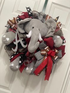 a wreath with an elephant and footballs is hanging on the front door for someone to decorate