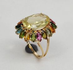 This stunning ring is set in 14k Solid Yellow Gold with Natural Lemon Topaz and Multi Tourmaline with utmost precision. It is an unique statement gemstone ring for nearly every occasion and is completely hassle-free jewelry. ITEM DETAILS * CENTER GEM: Lemon Topaz * GEM SIZE: 10X14mm  * GEM SHAPE: Oval cut * SIDE GEM: Multi Tourmaline * GEM SIZE: 2.5X5mm (18pc),  * GEM SHAPE: Marquise cut * TOTAL GEM WEIGHT: 6.80 carats * Gold Purity: 14KT * Gold Weight: 2.57 gram * Total Weight of the Ring: 3.93 Handmade Jewelry Box, Topaz Jewelry, London Blue Topaz Ring, Gold Gemstone Ring, Solid Gold Ring, Blue Topaz Stone, Alternative Engagement Rings, November Birthstone, Solid Gold Rings