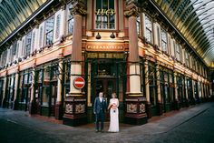 a man and woman standing in front of a building