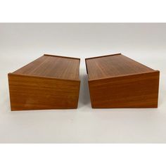 two wooden boxes sitting next to each other on a white surface with no one in it