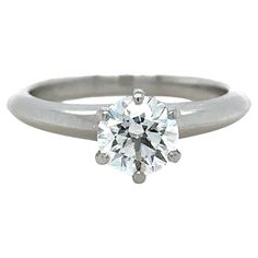 A Tiffany & Co, Diamond Engagement Ring, made of 950 Platinum, and weighing 5.84 gm. Stamped: Tiffany & Co. PT950 30297245. Set with a Round, brilliant cut Diamond, colour I, and clarity VS2. Weighing 1.00 ct. laser inscribed: T&Co. N08010008. Certificate provided from Tiffany & Co with Report # 30297245/N08010008. Metal: Platinum PT950 Carat: 1.00ct Colour: I Clarity: VS2 Cut: Round Brilliant Weight: 5.84 grams Engravings/Markings: Tiffany & Co. PT950 30297245. Size/Measurement: Ring Size L Current Condition: Excellent - Consistent with age and use. Accompanied by: This Tiffany & Co Engagement Ring 1.00ct is accompanied by Valuation Document Number AV 00006255 dated 17/01/2024 and original Tiffany & Co box and Tiffany & Co Diamond Certificate Report Number #30297245/N08010008. Along with Gia Certified Platinum Diamond Ring With Round Stone, Gia Certified Platinum Round Ring, Gia Certified Platinum Rings, Platinum Jewelry With Classic Cut Center Stone, Timeless Gia Certified Diamond Wedding Ring, Platinum Rings With Brilliant Cut Round Stone, Classic Gia Certified Round Stone Ring, Gia Certified Timeless Diamond Ring, Gia Certified Round Diamond Ring For Formal Occasions