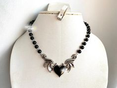 **PLEASE PLACE HOLIDAY ORDERS BEFORE DEC 14 7PM EST!! SHOP BREAK: ORDERS MADE AFTER DEC 15 WILL NOT BE DISPATCHED UNTIL JAN 2 ** THANK YOU ♥ gothic inspired black pearl choker with a winged black heart <3 adjustable chain and can be customized for various lengths.  each size will have a two inch extension to accommodate for different lengths or mismeasurements when measuring neck size the length of the pearls will not exceed 12-13 inches, the rest will be silver chain to accommodate larger sizes Black Heart-shaped Metal Choker, Black Heart-shaped Emo Choker, Black Grunge Necklace For Gift, Black Alternative Style Choker Necklace, Black Emo Choker Necklace, Emo Black Choker Necklace, Leather Heart Choker, Grunge Chokers, Edgy Y2k