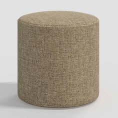 a small round ottoman with a light brown textured upholstered fabric on the top