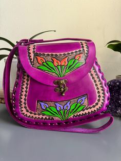 Beautiful, embossed, genuine leather hand tooled floral purse, skillfully made by Artisans in Mexico using the "cincelada" technique. Latch Closure and adjustable strap. Includes a storage bag to protect your purse when not in use.  Dimensions: 11" L x 4" W x 10'' H. Tapered at the top to create a truly unique style. Please check measurements if you have any concerns about sizing before purchase. Includes a dust bag as pictured, to protect your purse when not in use. Imported from Mexico, they are a continuation of the fine craftsmanship established in that country going back hundreds of years with carved leather saddles. These beauties are not like the more common stamped products that can be mass produced cheaply and sold. Each piece is hand-cut by skilled artisans in leather carving, pr Boho Chic Bags, Purse Handmade, Floral Purse, Leather Carving, Peace Lily, Tool Bag, Stitching Leather, Slow Fashion, Storage Bag