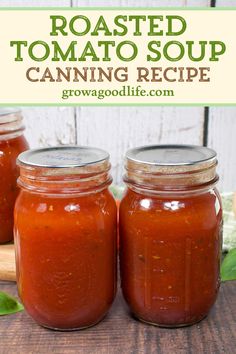 three jars filled with roasted tomato soup sitting on top of a wooden table