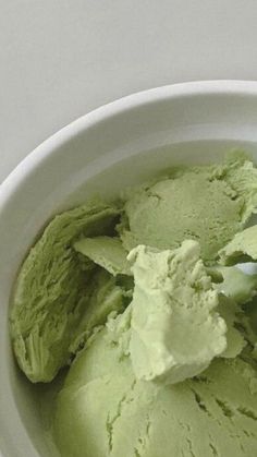 a white bowl filled with green ice cream