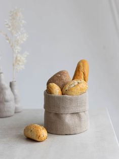 some bread and rolls in a bag on a table