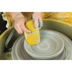 a person using a brush on a potter's wheel