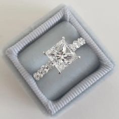 an engagement ring in a box with diamonds on it's sides and the center stone is