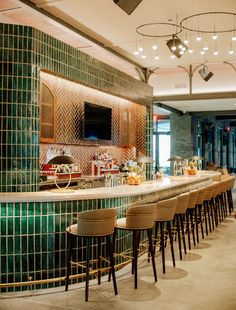 a bar with several stools in front of it and a television on the wall