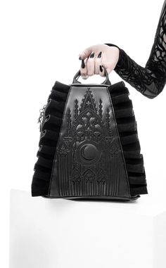 There's nothing quite as thrilling as a good flying buttress. Intricate black tonal embroidery depicts a Gothic cathedral and a large crescent, adding a mystical touch to the design Mesmerizing contrast of subtly shiny PU leather & deep black faux suede Faux suede ruffles exude elegance and romance Practical double zip main closure Convenient back zip pocket for quick-grab small items Side entry pockets hidden behind ruffles Silver crescent moon zipper pulls adorn the main opening, back pocket & Gothic Backpacks, Moon Backpack, Goth Purse, Flying Buttress, Gothic Purse, Gothic Bag, Midnight Moon, Suede Backpack, Unique Purses