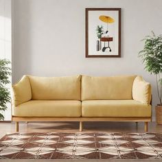 a living room with a couch and potted plants on the floor next to it