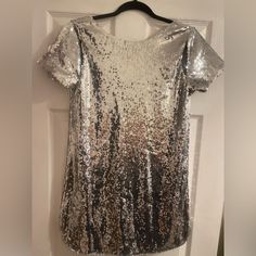 Do Not Miss Out On This Snag! You Will Stand Out And This Dress Is For Sure To Get Many Compliments. This T-Shirt Dress Has So Much Class And Edge To It! Can Dress It Up Or Down. Has A Low Cut Back And Some Cute Cut Outs In The Shoulder! Never Worn. I Love This Dress And Wish It Fit Me The Correct Way! Size Medium Still With Tags! Party Sequin Dress With Glitter And Short Sleeves, Glamorous Short Sleeve Sequin Dress With Contrast Sequins, Glitter Short Sleeve Dresses For Parties, Metallic Shine Dresses For Party Season, Glamorous Short Sleeve Contrast Sequin Dress, Short Sleeve Glitter Dress For Party, Glamorous Short Sleeve Sequin Dress With Contrast, Glitter Short Sleeve Party Dress, Short Sleeve Glitter Party Dress