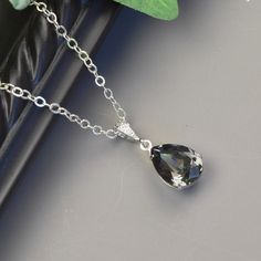 "Charcoal gray necklace featuring a gray swarovski crystal teardrop in a sterling silver plated prong setting attached to a cubic zirconia rhodium bail on a sterling silver chain. The pendant necklace is a deep rich shade of charcoal gray. The perfect necklace for a special occasion and beautiful enough for your bridesmaid jewelry. The pendant is 1 1/4\" long. The chain is sterling silver with a lobster claw clasp and 1 1/2\" extender chain. Multiples available. Message me for pricing. * swarovs Silver Cubic Zirconia Necklace For Bridesmaid, Elegant Gray Pendant Jewelry, Formal Silver Pear-shaped Drop Necklace, Silver Teardrop Pendant Necklace For Formal Occasions, Silver Teardrop Pendant Necklace For Bridesmaid Gift, Silver Teardrop Pendant Jewelry For Bridesmaid Gift, Silver Crystal Teardrop Pendant Necklace, Silver Cubic Zirconia Teardrop Pendant Necklace, Silver Teardrop Cubic Zirconia Drop Necklace