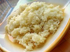 rice on a yellow and white plate with a wooden table in the backgroud