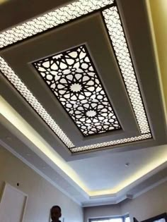 the ceiling in this room is decorated with intricate patterns and lights, along with a large window