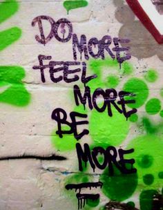 graffiti written on the side of a white brick wall with green leaves and words that read do more feel more be more