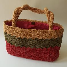 a multicolored handbag sitting on top of a white table