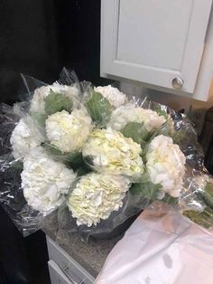 a bouquet of white flowers sitting on top of a counter