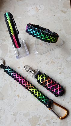 three keychains with different colors and designs on them sitting on a table next to each other